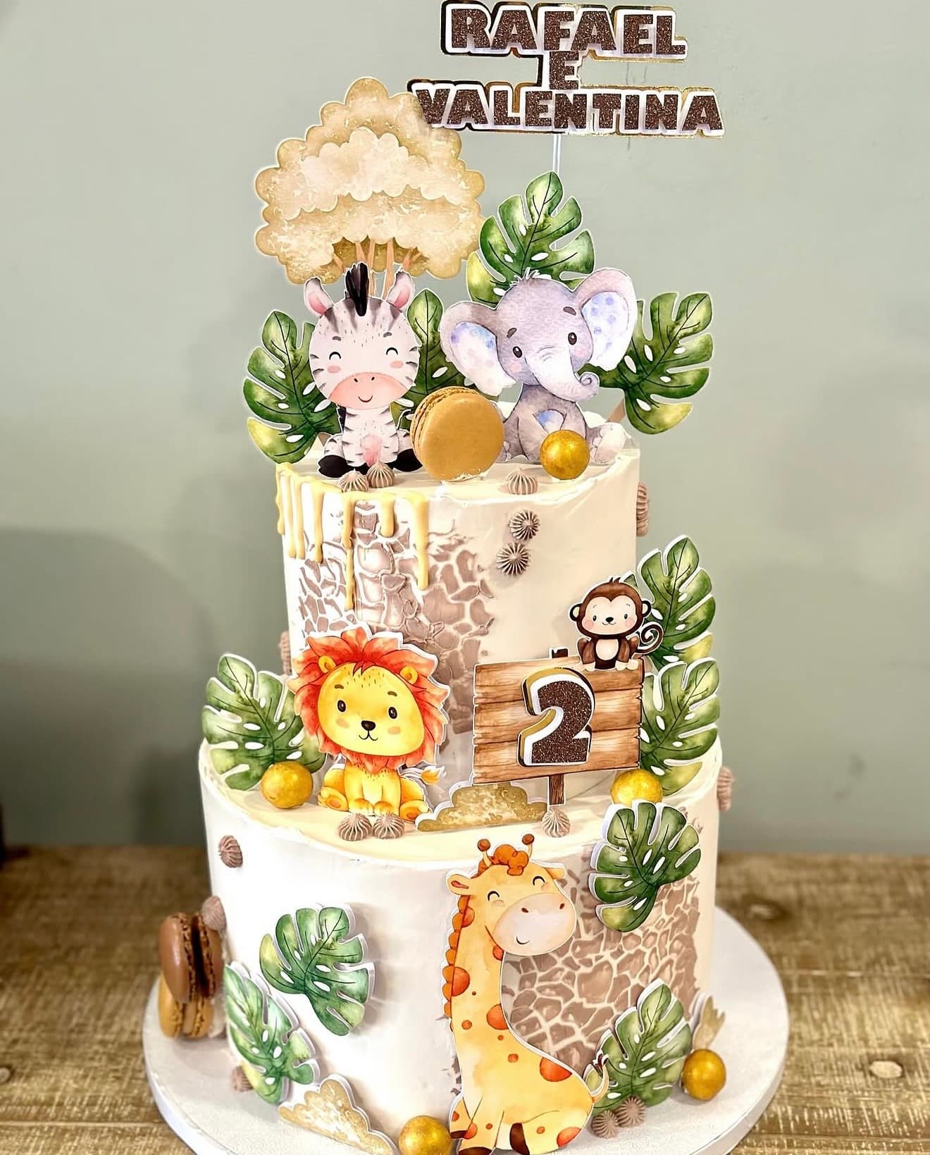 Safari Gémeos — Dois andares com leão, girafa, macaco, folhas monstera e detalhes dourados para gémeos.